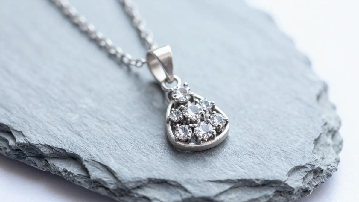 Silver pendant necklace with three sparkling simulated diamond stones hanging on a velvet display bust