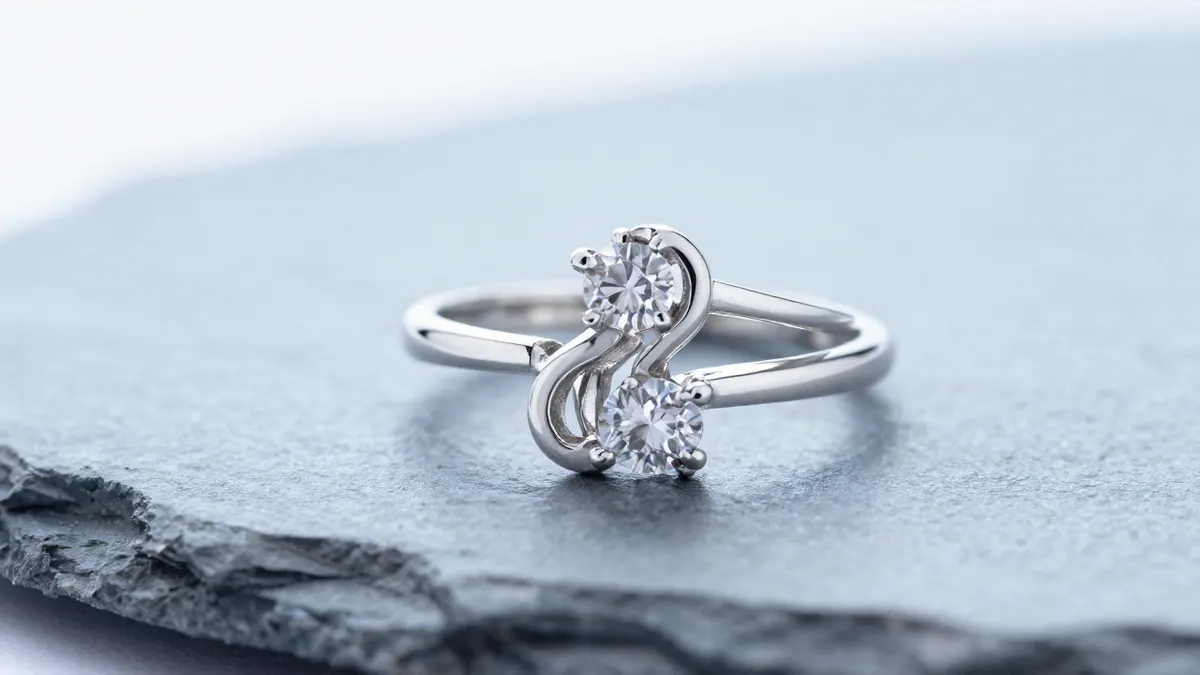 Sterling silver two stone ring with sparkling simulated diamonds set side by side on dark slate