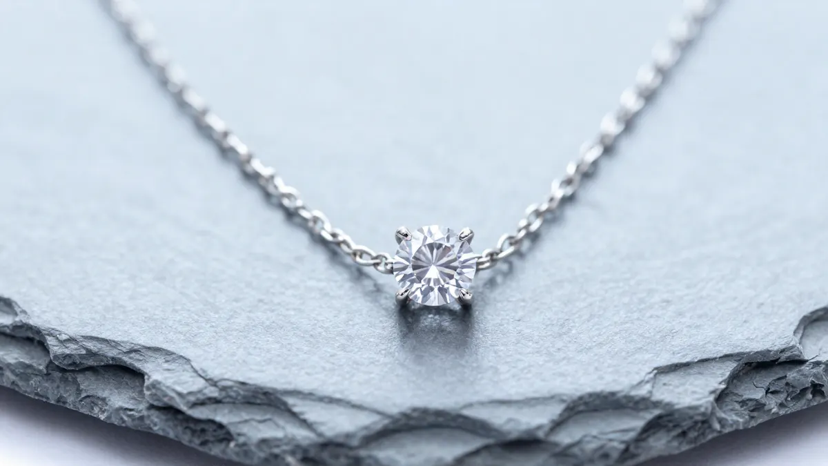 Sterling silver solitaire pendant necklace with a sparkling simulated diamond draped on dark velvet