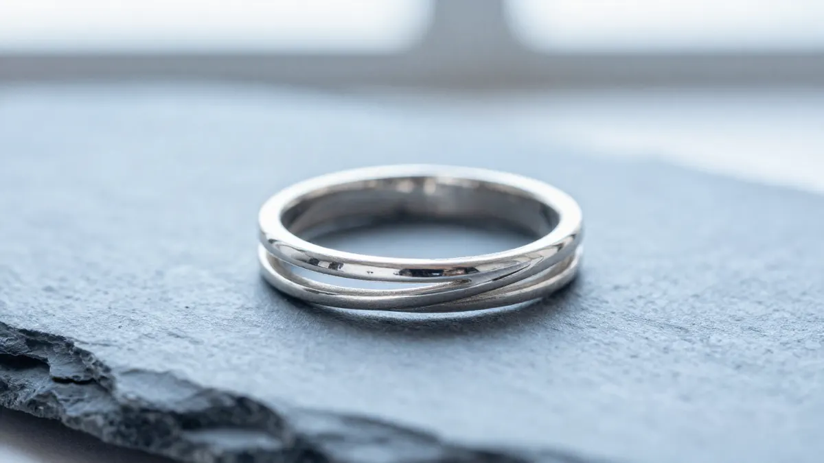 Sterling silver forever ring with a sleek infinity loop design resting beside white flowers in morning light